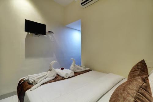a bedroom with a bed with two swans on it at New Parimeet Residency in Navi Mumbai