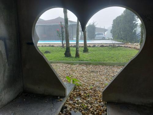 a heart shaped window with a view of a park at Pitaya Haus Lofts in Brusque