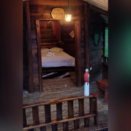 a bedroom in a log cabin with a bed at Villa Emboscada Glamping in Silvania
