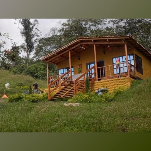 a small house with a porch and a deck at Villa Emboscada Glamping in Silvania