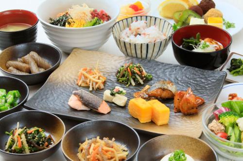 a table topped with bowls of different types of food at Richmond Hotel Premier Musashikosugi in Kawasaki