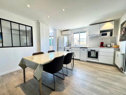 une cuisine et une salle à manger avec une table et des chaises dans l'établissement Le Saint-Jean By SCLS Locations, à Cannes