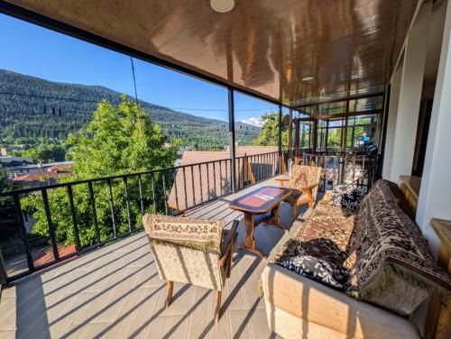 a balcony with furniture and a view of the mountains at Guesthouse Data in Mestia
