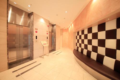 a hallway with a checkered wall in a building at Richmond Hotel Premier Musashikosugi in Kawasaki