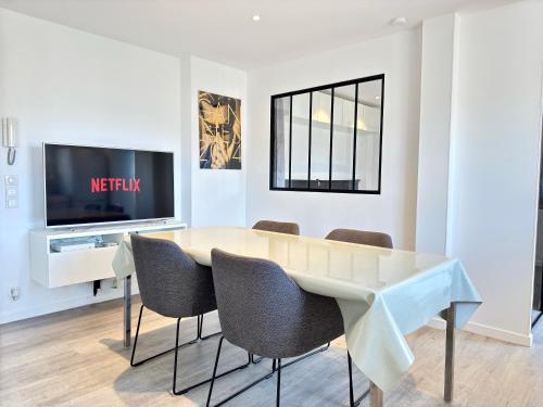 une salle à manger avec une table et des chaises et une télévision dans l'établissement Le Saint-Jean By SCLS Locations, à Cannes