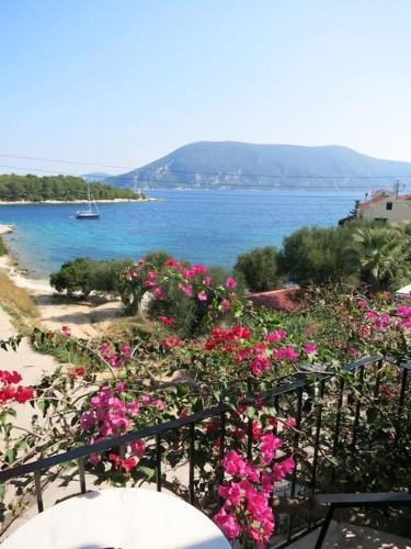 un mazzo di fiori rosa su una ringhiera vicino all'acqua di Vassili's Apartment, Kefalonia a Fiskardho