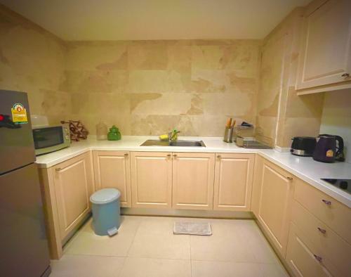 une petite cuisine avec un évier et un micro-ondes dans l'établissement Marakesh Hua Hin Resident-Room Type E, à Hua Hin