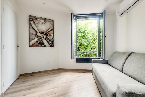 un salon avec un canapé et une fenêtre dans l'établissement Résidence 4T- boulevard de l'hôtel de ville, à Aulnay-sous-Bois