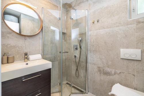 a bathroom with a shower with a sink and a mirror at Villa Haya with heated pool in Linardići