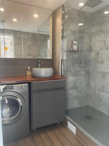 une salle de bain avec un lavabo et une machine à laver dans l'établissement Panoramique vue NEW design proche Tour Eiffel, à Paris