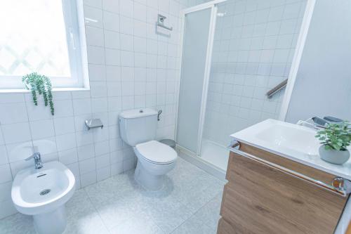 a white bathroom with a toilet and a sink at Embrujo Andaluz Complejo Rural Órgiva in Órgiva