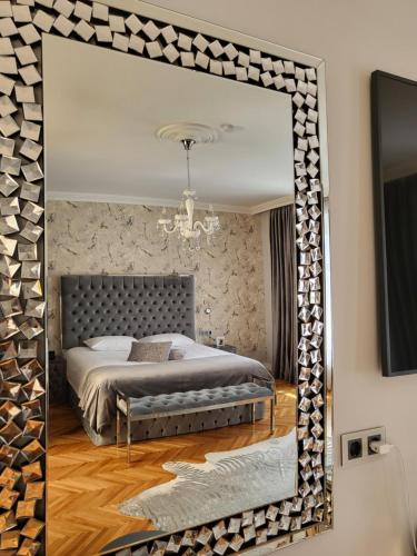 a mirror reflecting a bedroom with a bed in it at Fancy Flats in Sibiu
