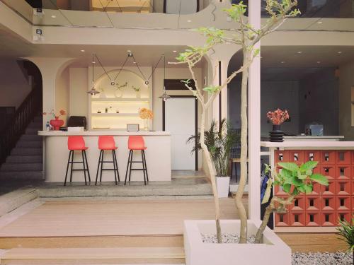 a house with red stools and a kitchen with a counter at Dali Vietian Guesthouse微甜 in Dali