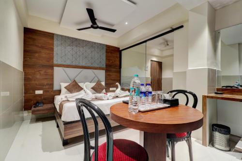 a bedroom with a bed and a table with water bottles on it at New Parimeet Residency in Navi Mumbai
