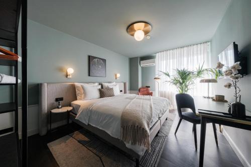 a bedroom with a bed and a desk and a table sidx sidx sidx at Mercure Hotel Pforzheim in Pforzheim