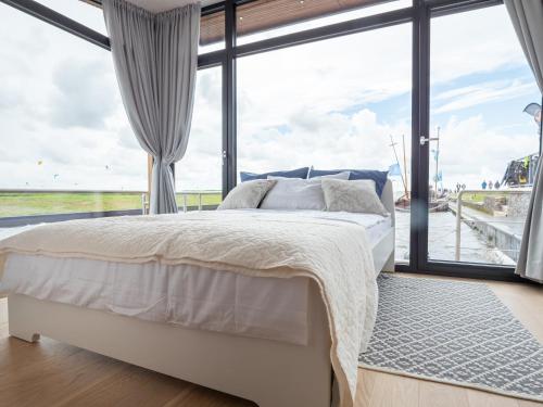 a bedroom with a bed and a large window at Twin Boats - Butterfly in Dreverna