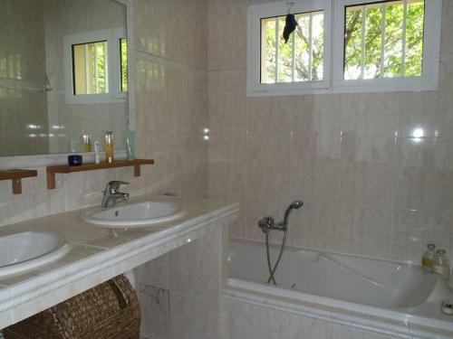 une salle de bain avec deux lavabos et une baignoire dans l'établissement Villa contemporaine de plain pied Biot, à Biot