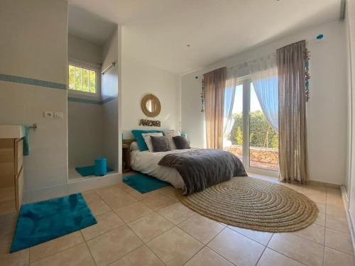 une chambre avec un lit et une grande fenêtre dans l'établissement Villa contemporaine de plain pied Biot, à Biot