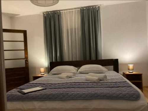 a bedroom with a bed with two towels on it at Casuta din Padure in Bodeşti