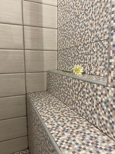 a shower with a bench in a bathroom with tiles at FOUR SEASOΝ Konstantinas in Áyios Thomás