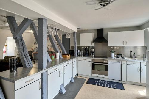 a kitchen with white cabinets and white appliances at Appartement de caractère, charme in Nevers