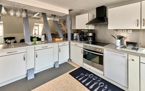 a large kitchen with white cabinets and appliances at Appartement de caractère, charme in Nevers