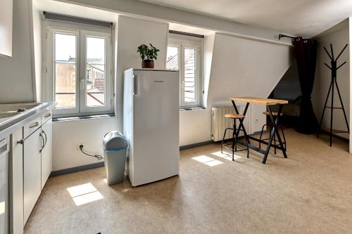 a white refrigerator in a kitchen with a table at Appartement de caractère, charme in Nevers