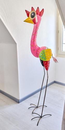 a fake pink flamingo statue in a room at Appartement de caractère, charme in Nevers