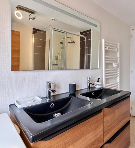 a bathroom with two sinks and a large mirror at Appartement de caractère, charme in Nevers