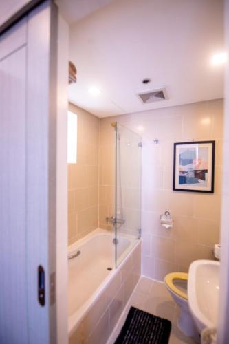 a bathroom with a tub and a toilet and a sink at Antel Spa & Serenity Suites in Manila
