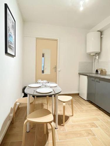 une cuisine avec une table et des chaises dans une pièce dans l'établissement 721 Appartement fonctionnel proche du métro ligne 9, à Bagnolet