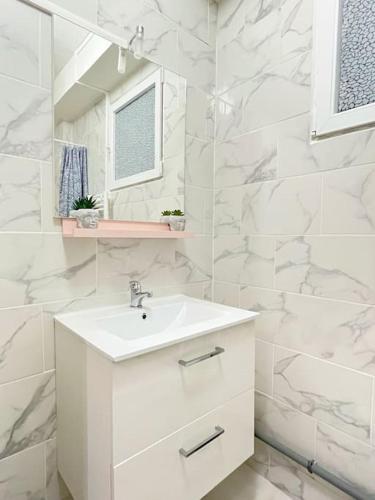 une salle de bain blanche avec un lavabo et un miroir dans l'établissement 721 Appartement fonctionnel proche du métro ligne 9, à Bagnolet