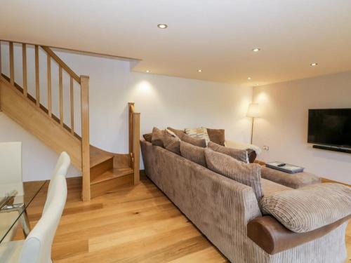 a living room with a couch and a flat screen tv at Bridge Cottage in Newby Bridge