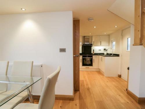 a kitchen and dining room with a glass table and chairs at Bridge Cottage in Newby Bridge