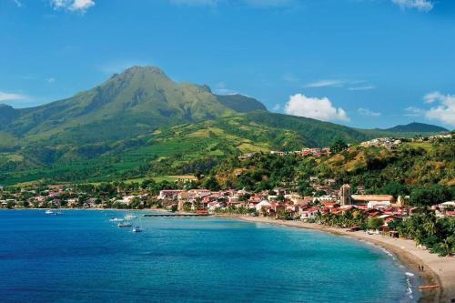una vista di una spiaggia con barche in acqua di Kaz IXORA a Les Anses-d'Arlets