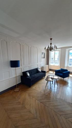 a living room with a blue couch and a table at Le bon secours in Murat