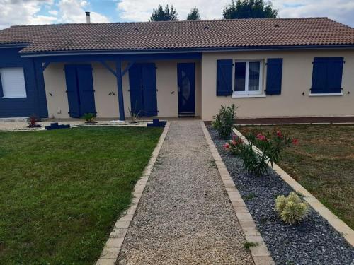 une maison avec des portes bleues et une cour dans l'établissement Petit studio independant mitoyen à la maison, à Jaunay-Clan