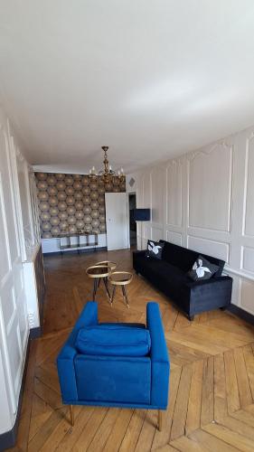 a living room with a blue couch and a table at Le bon secours in Murat