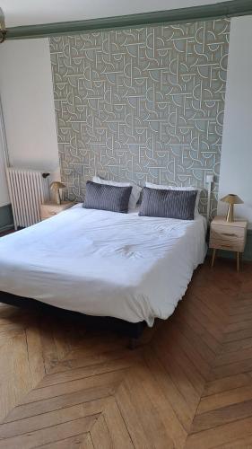 a large bed in a bedroom with a wall at Le bon secours in Murat