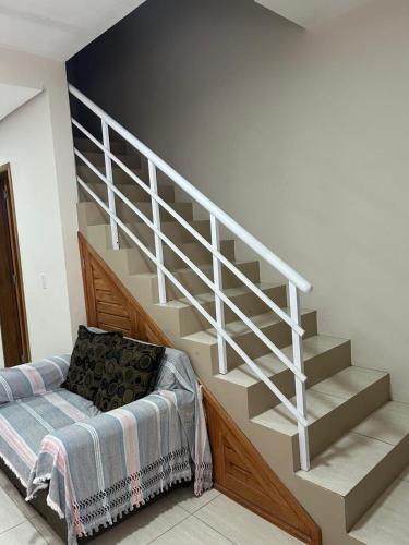 a white staircase with a bed in a room at duplex aconchegante in Tramandaí