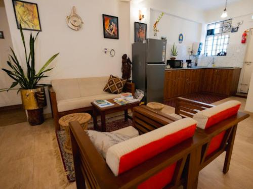a living room with a couch and a kitchen at La Lune Fort Kochi in Cochin