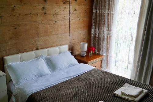 a bedroom with a white bed with a window at Guesthouse Anri in Shuakhevi