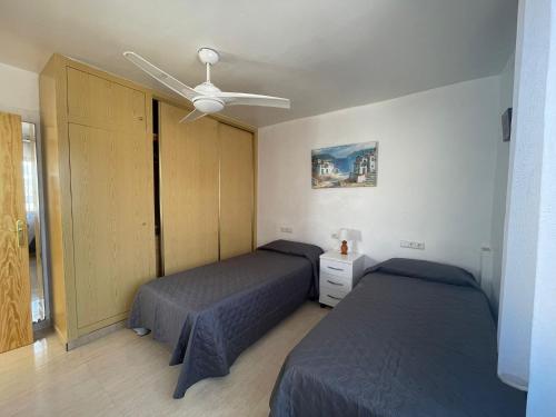 a bedroom with two beds and a ceiling fan at Mero Habitaciones in Cabo de Palos