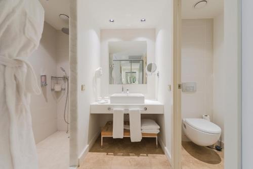 a white bathroom with a sink and a toilet at TUI Blue Barut Andız - All Inclusive - Adults Only in Side