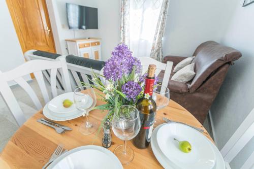 a table with a bottle of wine and flowers on it at Embrujo Andaluz Complejo Rural Órgiva in Órgiva