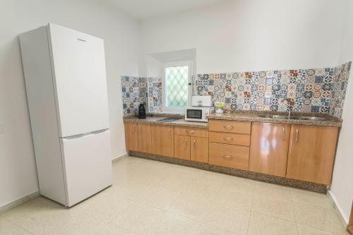 a kitchen with a white refrigerator and a microwave at Embrujo Andaluz Complejo Rural Órgiva in Órgiva