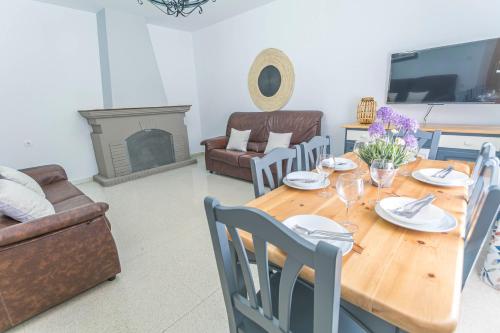 a living room with a wooden table and a fireplace at Embrujo Andaluz Complejo Rural Órgiva in Órgiva
