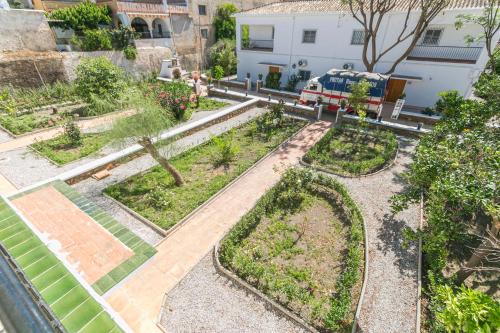 an aerial view of a garden with a fire truck in the background at Embrujo Andaluz Complejo Rural Órgiva in Órgiva
