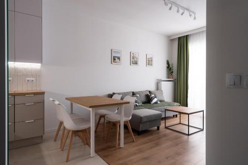a living room with a table and a couch at RentPlanet - Kępa Mieszczańska in Wrocław