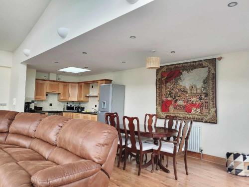 a living room with a couch and a table with chairs at Panoramic Two-bedroom Penthouse in Cork